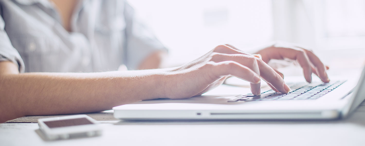 Image of Woman typing at a keyboard.